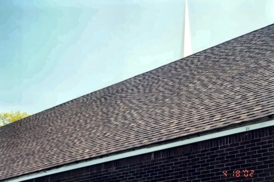 Completed architectural shingle roof on a church building below its steeple, an earlier commercial roofing project from the career of CEO James Stirling